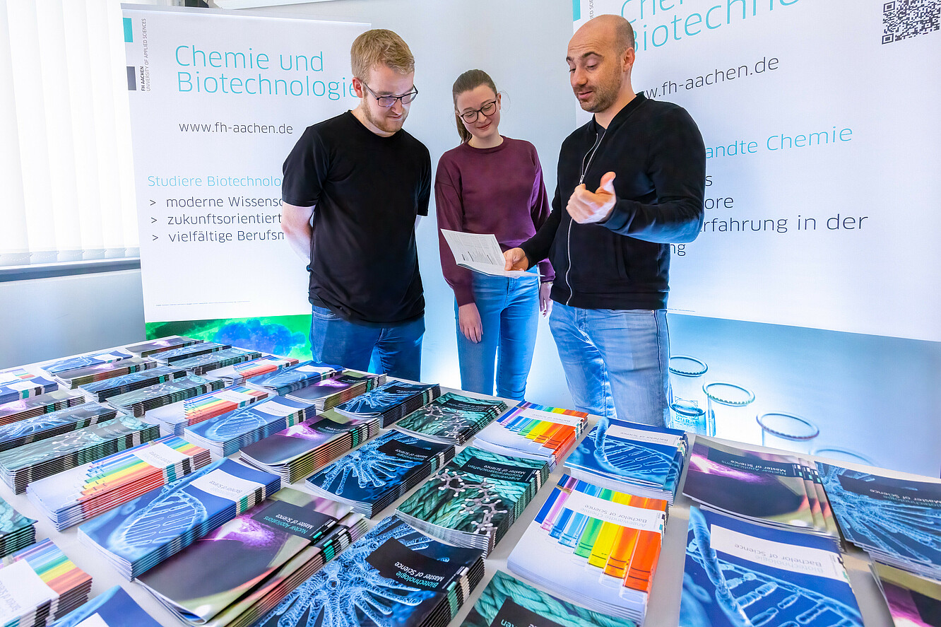 Studieninteressierte am Infostand Chemie und Biotechnologie, Schüler:innen und Berater im Gespräch