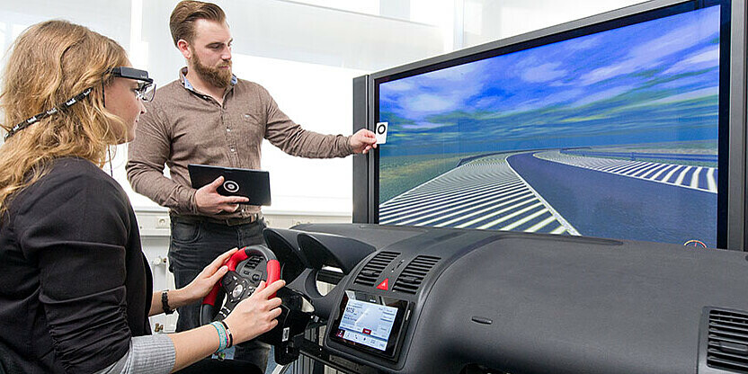 Student und Studentin bei Fahrsimulation