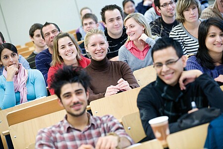 A section of a lecture hall filled with smiling people.